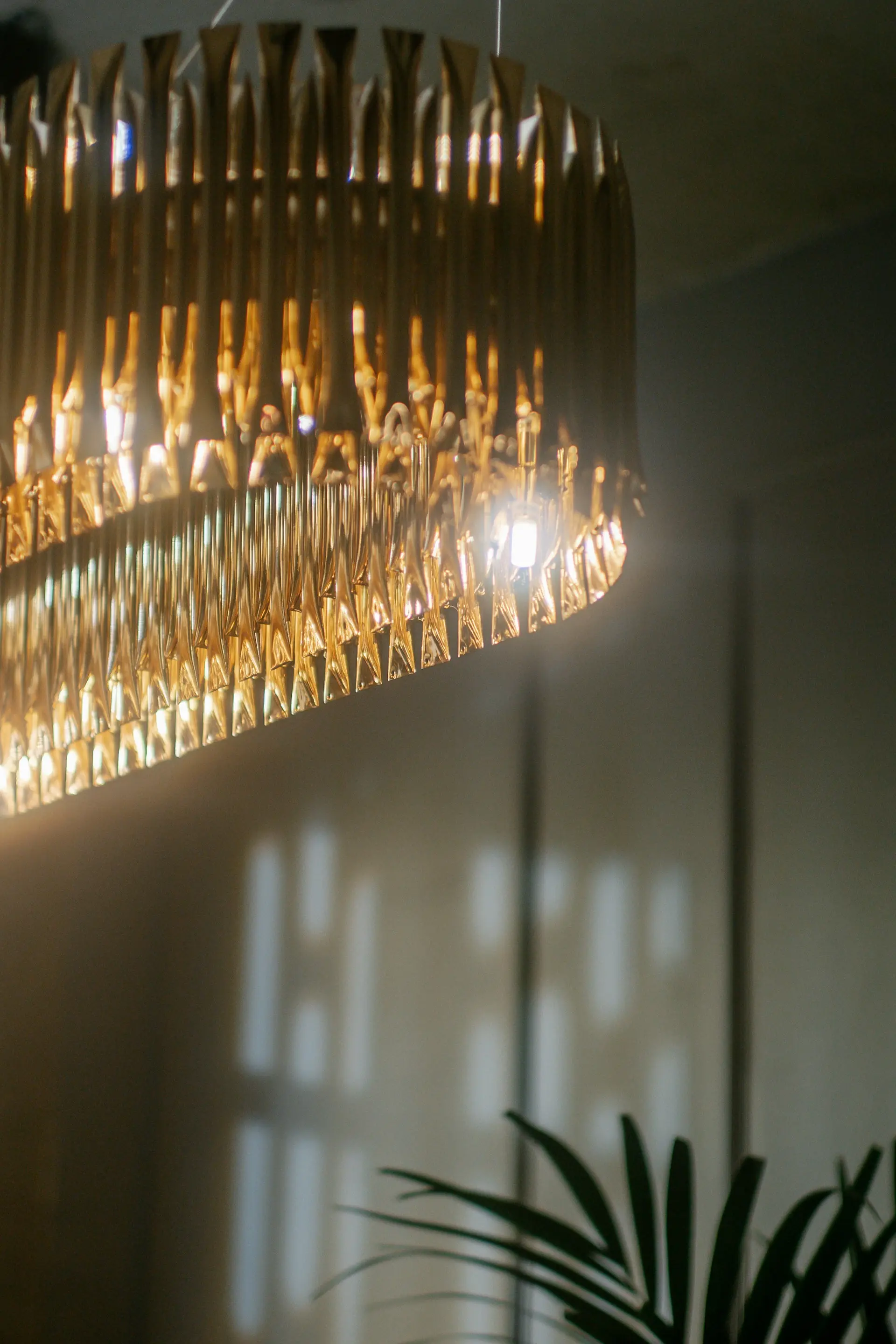 A brass chandelier casting warm light across a showroom wall